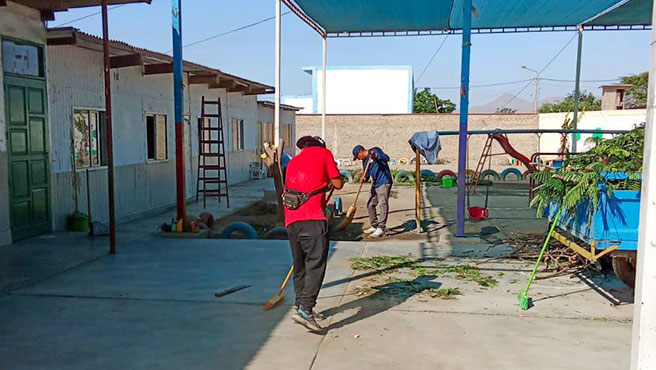 Personal obrero barriendo el patio recreativo