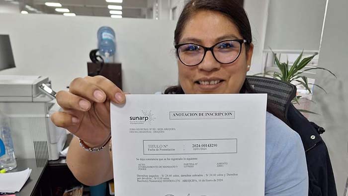 Foto de Mujer sentada en silla giratoria muestra hoja impresa de poder consular
