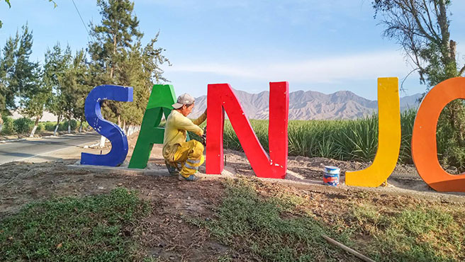 Personal edil pintando las grandes letras ciudades de ingreso al centro poblado de San José