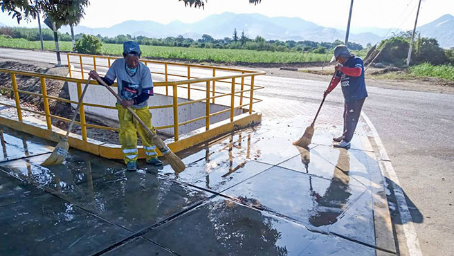 Trabajadores municipales baldeando el paradero de la localidad de San José