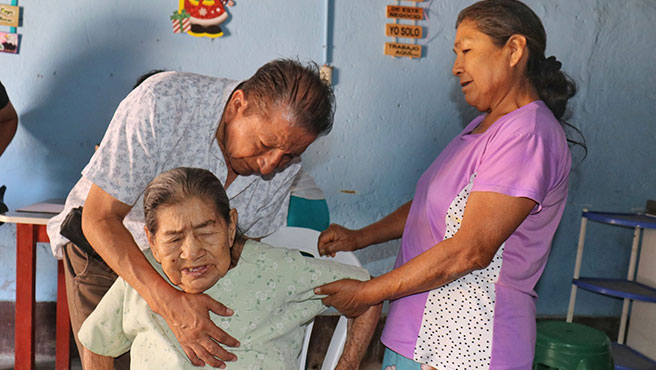 Médico certificador revisando revisando los pulmones adulto mayor