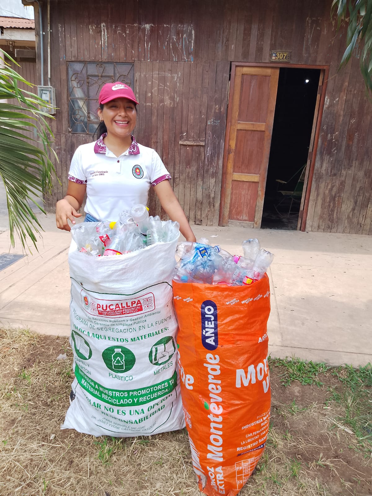 Promotora ambiental con botellas de plástico reciclado por los vecinos 