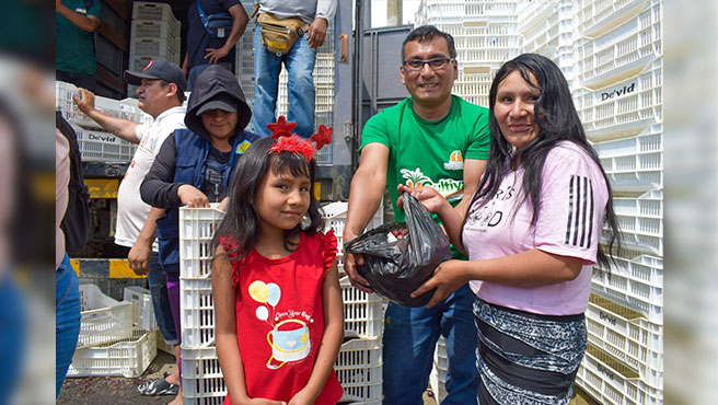 El regidor Gabriel Meregildo Melgarejo junto a una familia que recibiรณ uva orgรกnica