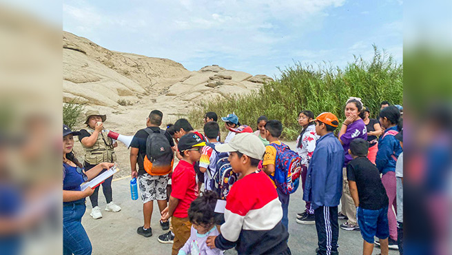 Niños y adolescentes recibiendo información sobre La Cruz del Siglo y El Rastro de la Culebra