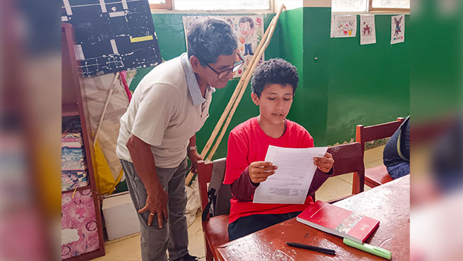 Facilitador leyendo el escrito de un niño