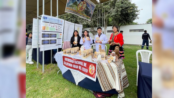 Becaria en una feria mostrando el producto