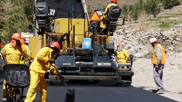 Maquinaria y operadores asfaltandotelas una pista en Perú.