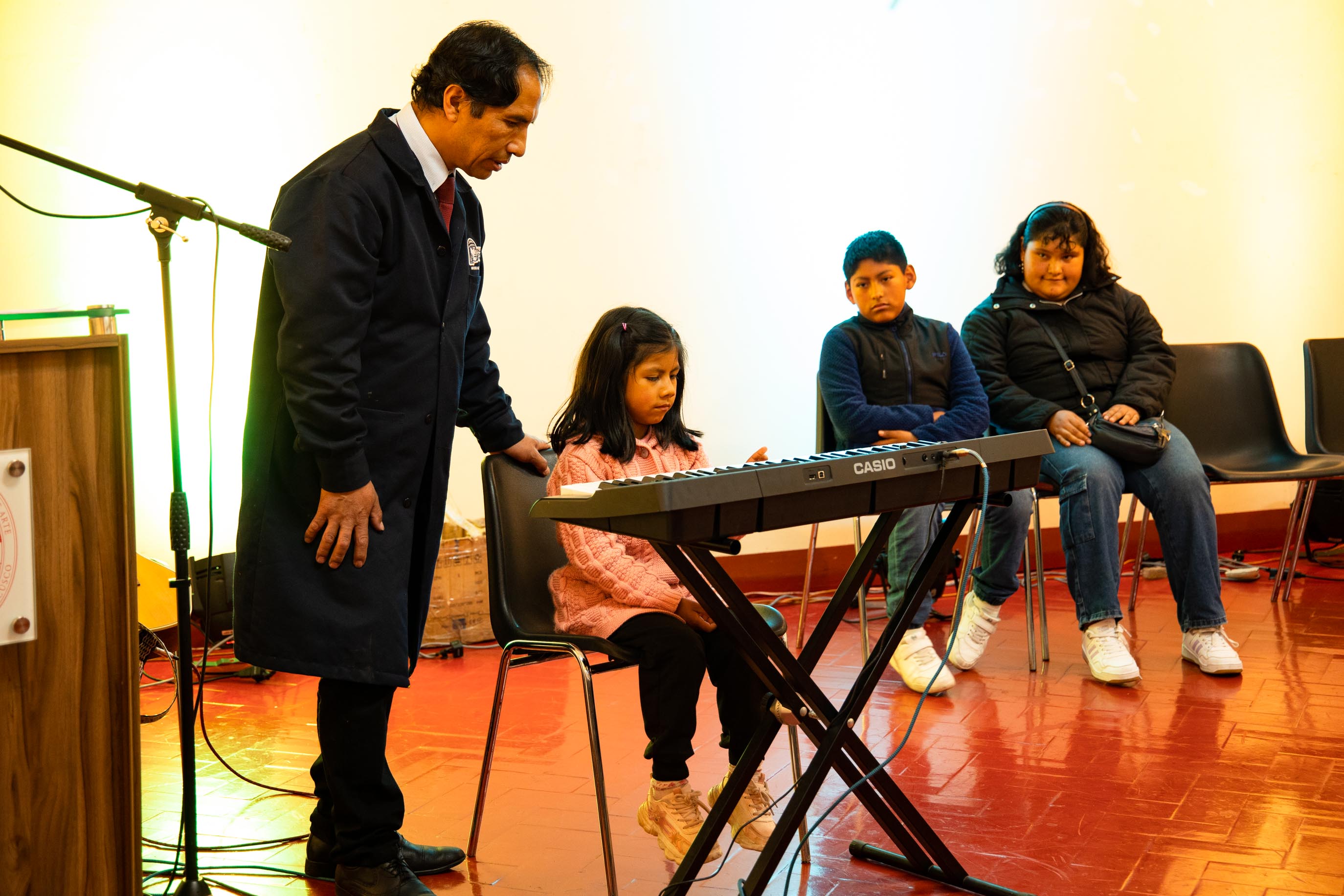Profesor Leonardo Huaman siendo guía de niña en el piano 