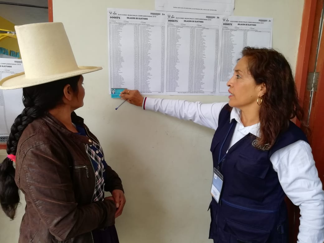Mujer cajamarquina revisanso la lista de votantes.