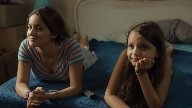 Escena de la película "Reinas" que muestras dos niñas viendo televisión.