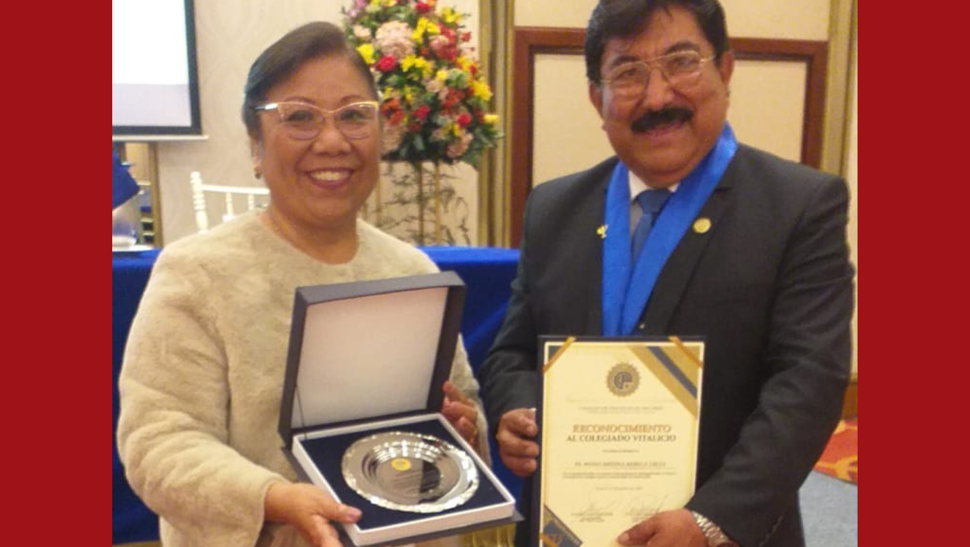 Rebeca recibiendo reconocimiento de un representante del colegio de psicólogos.
