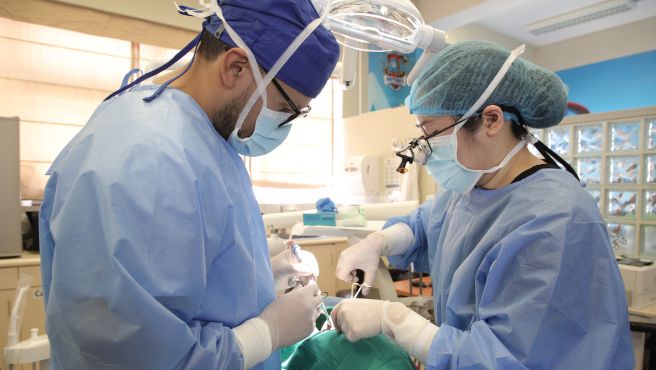 Pasante extranjera realizando procedimiento dental en el Heves