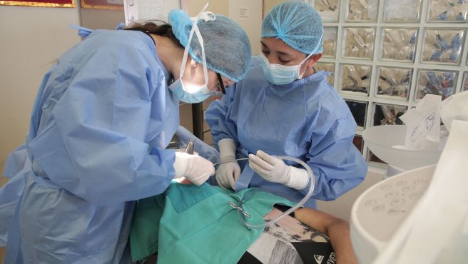 Pasante extranjera realizando procedimiento dental en el Heves