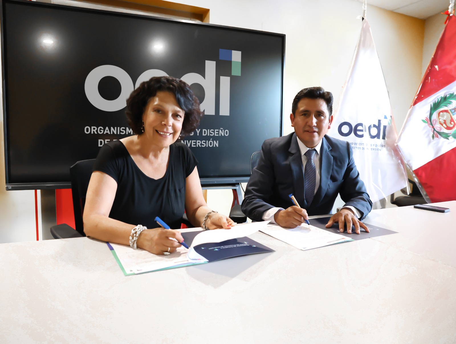 Jefa del OEDI firmando convenio