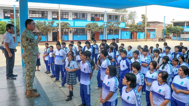 Alumnos recibiendo información sobre el trámite de la libreta militar 