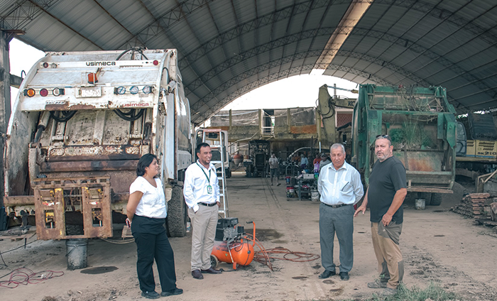 foto de los regidores y el gerente municipal en un taller de reparación de las compactadoras