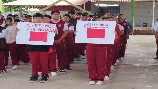 Niños con tarjeta roja en la mano, participan de la campaña.
