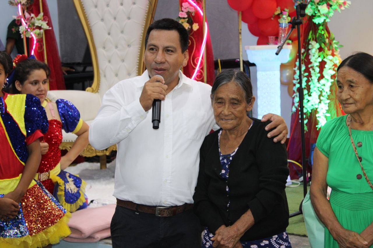 gerente de desarrollo social feliz de estar al lado de una mamita que gano su canasta