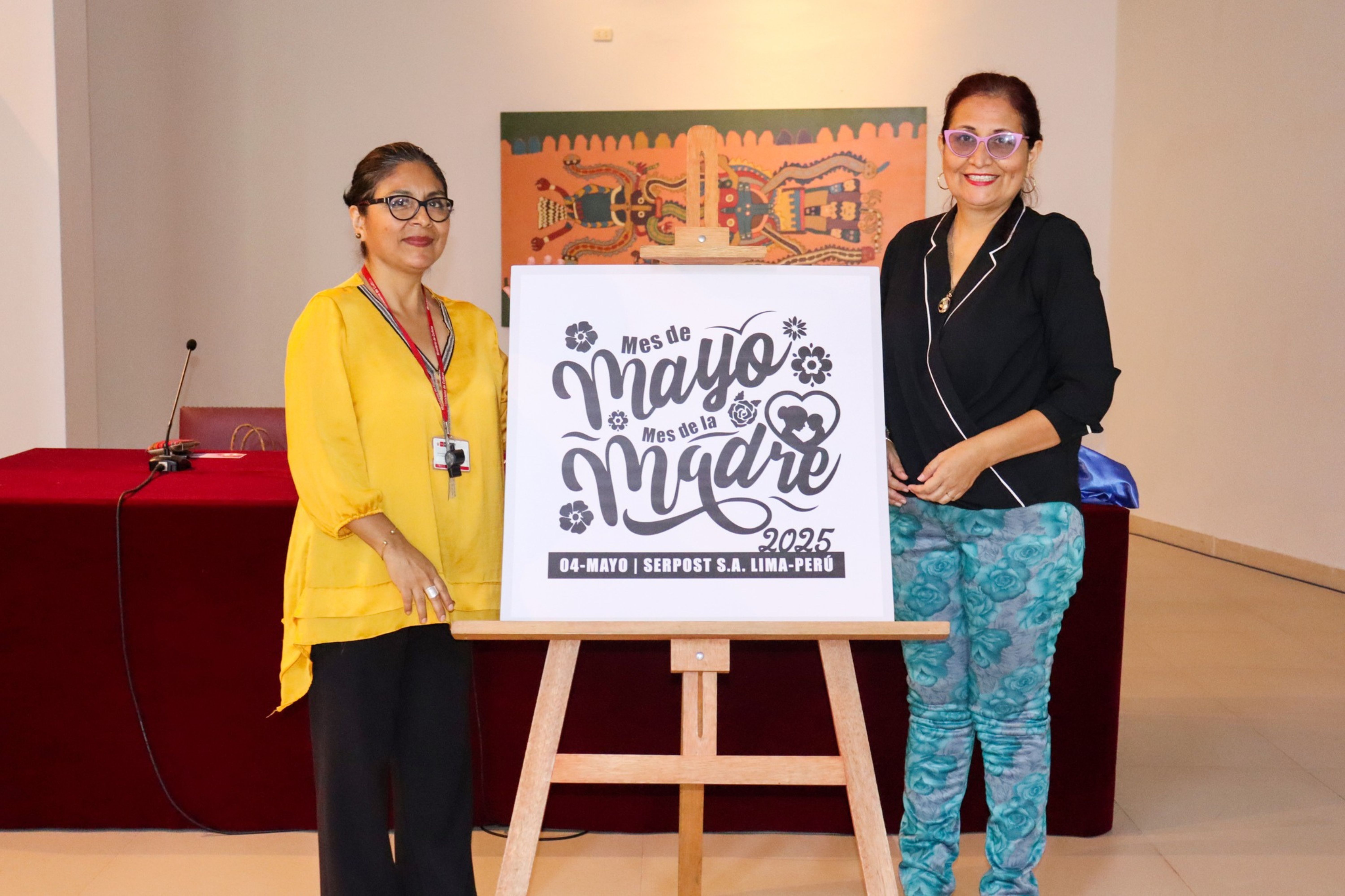 La Sra. Patricia Champa Huamalíes, directora del Museo Postal y Filatélico del Perú, y la Sra. Mónica Macedo, subgerenta de Marketing y Filatelia de Serpost, junto a la ampliación del matasello temático en homenaje al mes de mayo y al Día de las Madres.