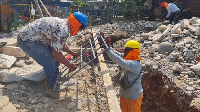 Obreros trabajando en la construcción de un nuevo salón y servicios higiénicos.