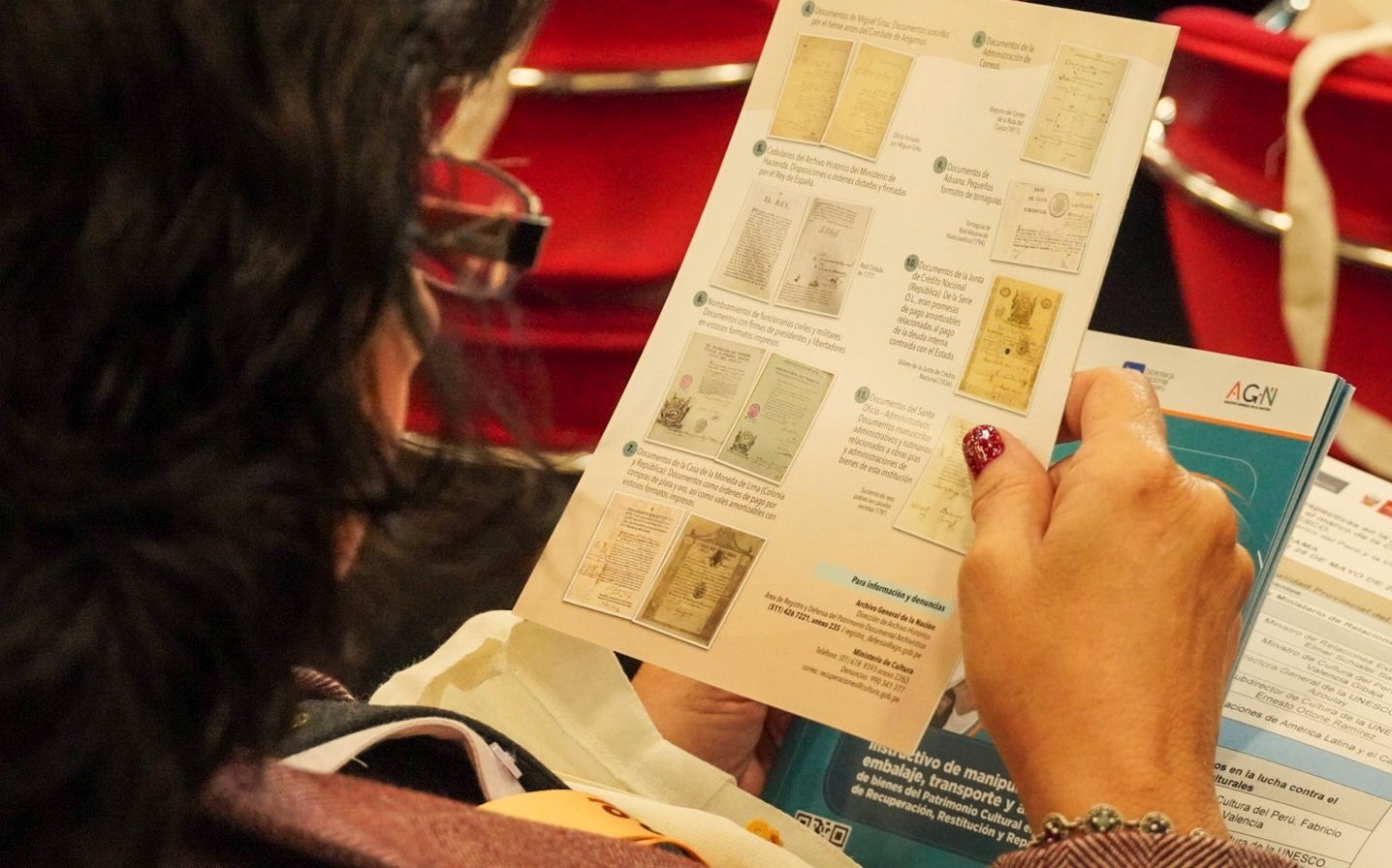 Imagen de jefa AGN viendo un folleto sobre tráfico ilícito de documentos