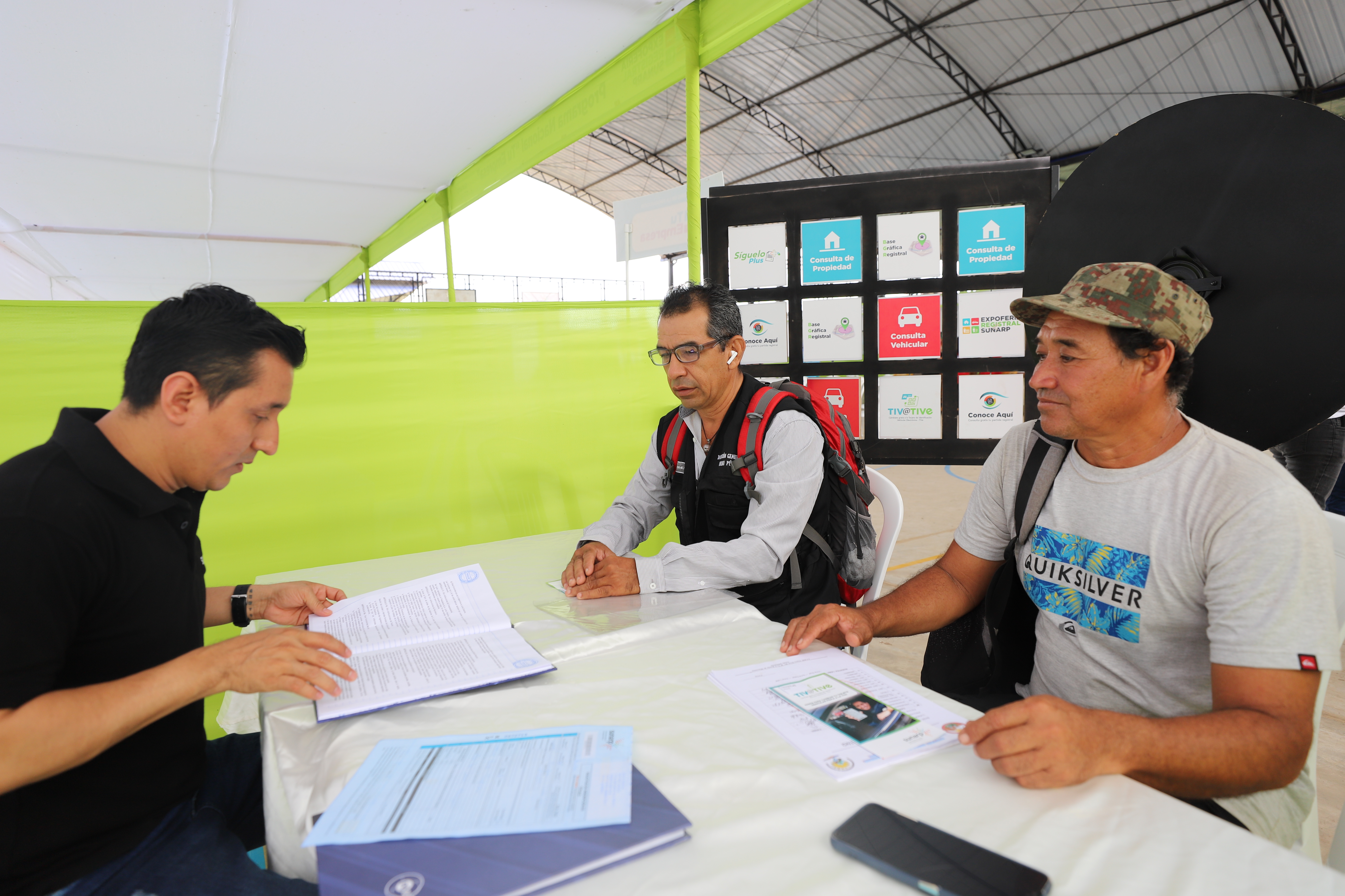 Foto de Servidores de Sunarp Pucallpa dan información a dos personas