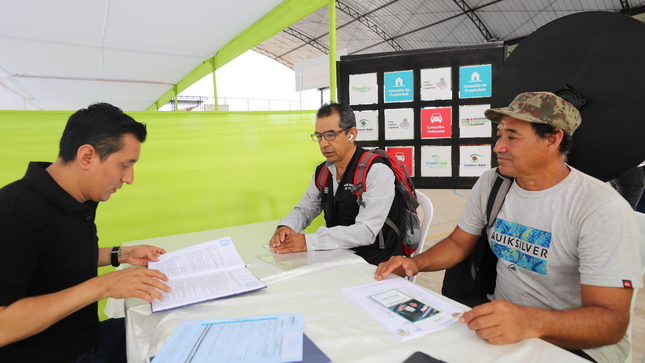 Foto de Servidores de Sunarp Pucallpa dan información a dos personas