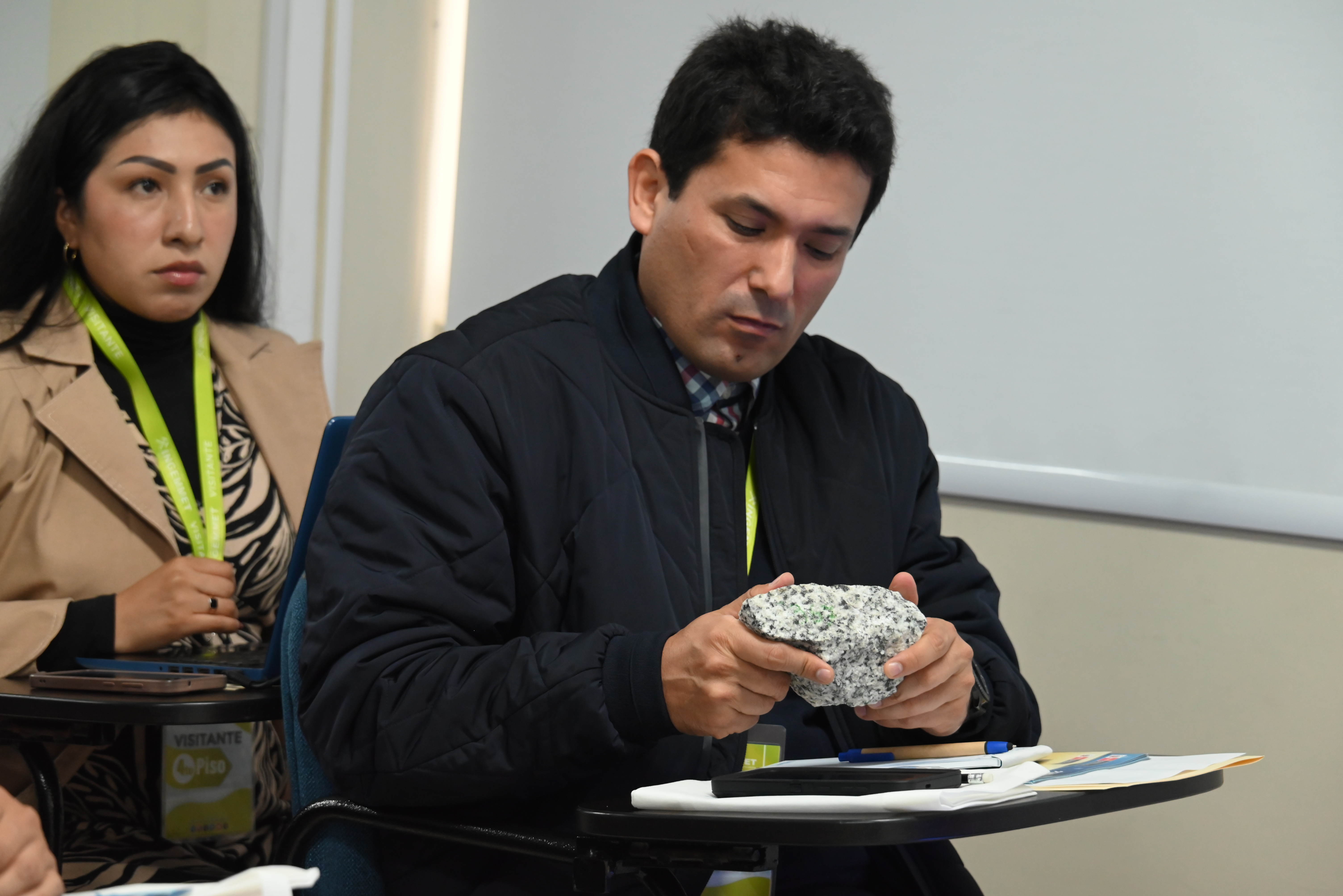 Comandante FAP Gary Perez observando de cerca un pedazo de roca durante el taller del Ingemmet.