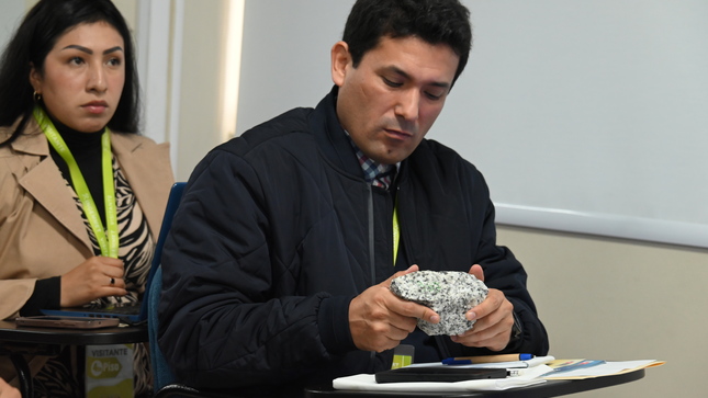 Comandante FAP Gary Perez observando de cerca un pedazo de roca durante el taller del Ingemmet.