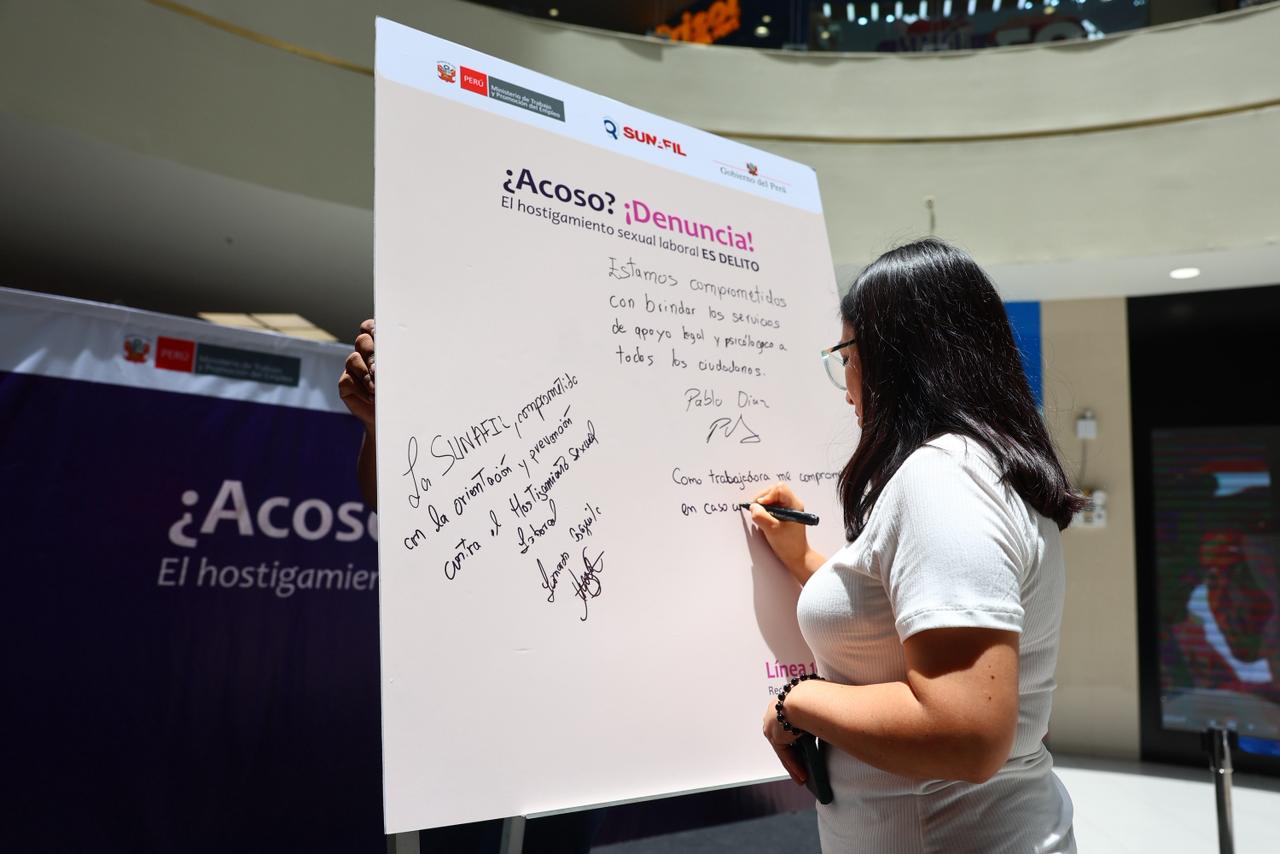 Foto de mujer firmando un pizarrón 