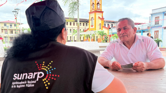 Fotografía de Adulto mayor recibiendo información por parte de servidora de la Sunarp